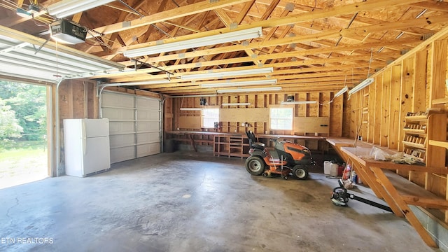 garage with white fridge and a garage door opener