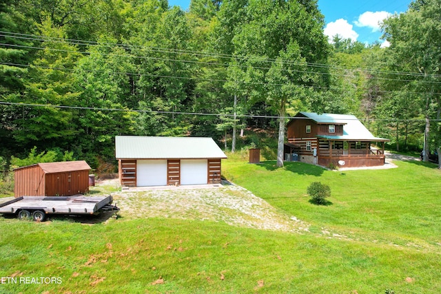 view of front facade with a front yard, an outdoor structure, and a garage