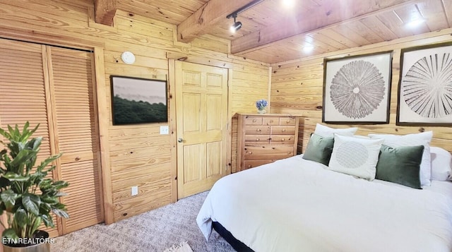 bedroom with beam ceiling, carpet floors, wooden ceiling, and wood walls