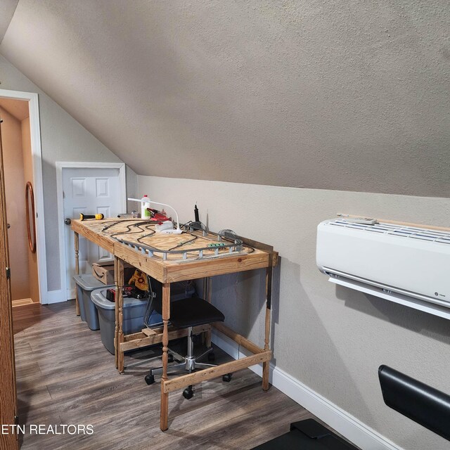 interior space featuring lofted ceiling, an AC wall unit, and dark hardwood / wood-style flooring