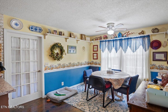 dining area featuring a textured ceiling, a ceiling fan, and wood finished floors