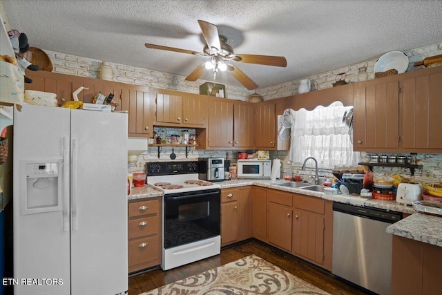 kitchen with brown cabinetry, white appliances, light countertops, and a sink