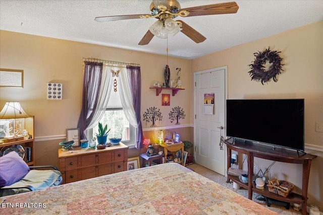 bedroom featuring a textured ceiling, ceiling fan, and light colored carpet