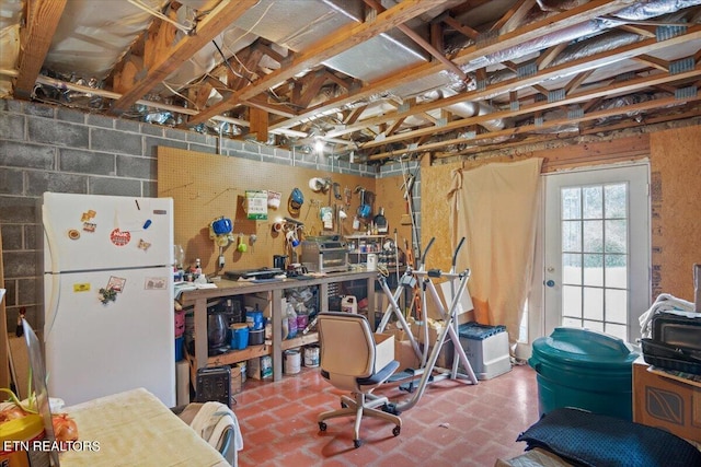 interior space featuring freestanding refrigerator and a workshop area