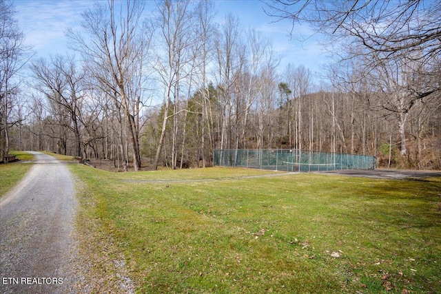 exterior space with a forest view and fence