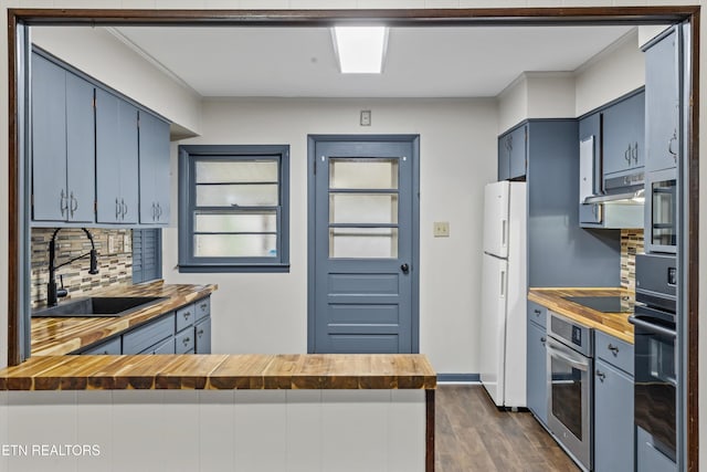 kitchen featuring blue cabinetry, a sink, wood counters, and black appliances