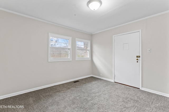 spare room featuring ornamental molding, carpet, visible vents, and baseboards