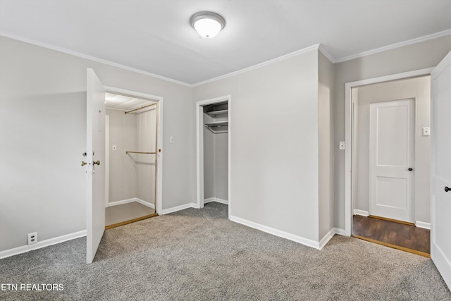 unfurnished bedroom featuring carpet floors, a closet, baseboards, and crown molding