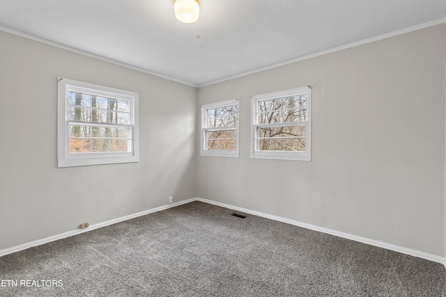 carpeted spare room with ornamental molding, visible vents, and baseboards