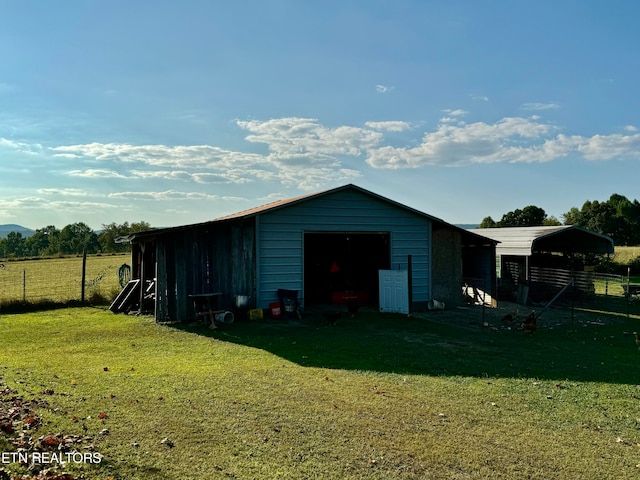 view of outbuilding with a rural view and a yard