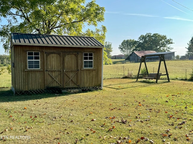 view of outbuilding with a lawn and a rural view