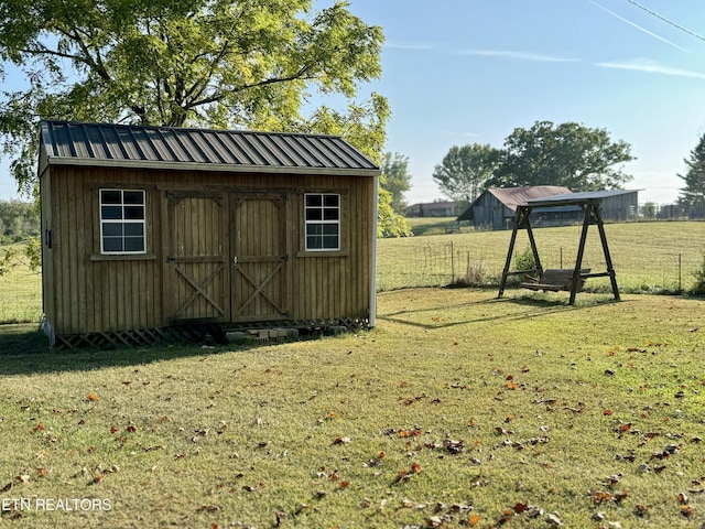 view of shed featuring a rural view and fence