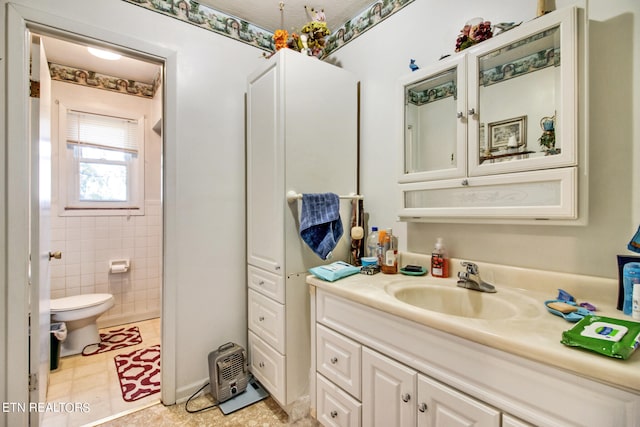 bathroom featuring toilet, vanity, and tile walls