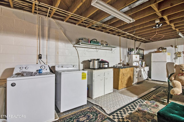 laundry area with dark floors, separate washer and dryer, and cabinet space