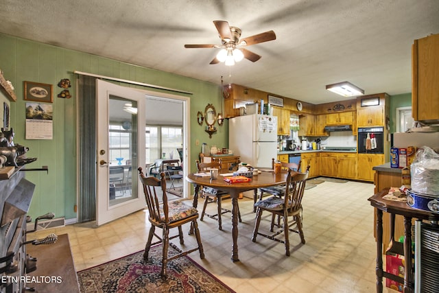 dining space with ceiling fan, a textured ceiling, and light floors