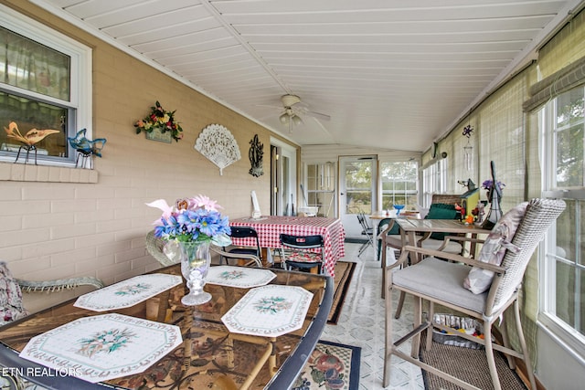 sunroom / solarium with plenty of natural light, vaulted ceiling, and a ceiling fan