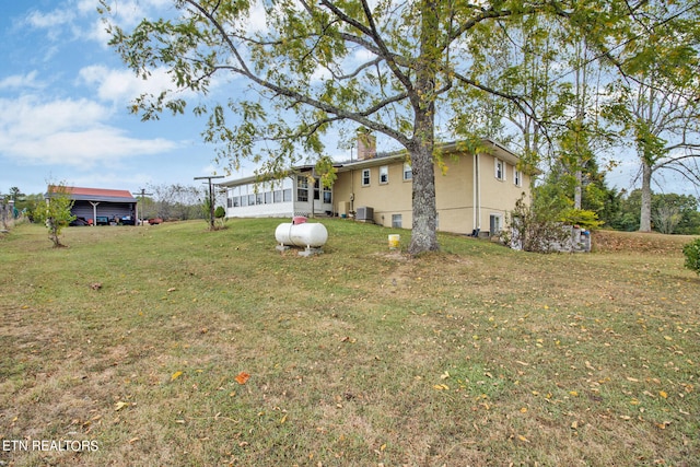 view of yard featuring central AC and a sunroom