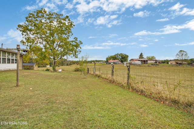 view of yard with a rural view and fence