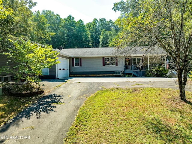 ranch-style home with a porch, a front yard, and a garage