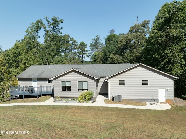 exterior space with a deck, a front yard, and central AC unit