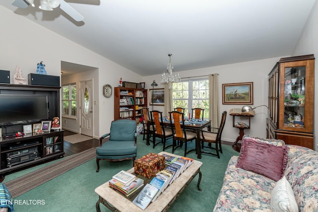 carpeted living room featuring ceiling fan with notable chandelier and vaulted ceiling