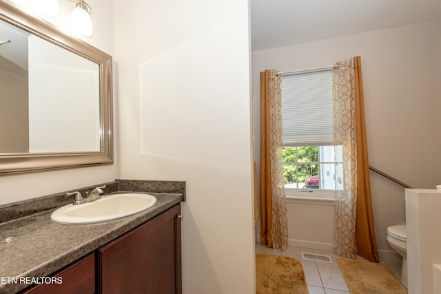 bathroom with toilet, tile patterned flooring, and vanity