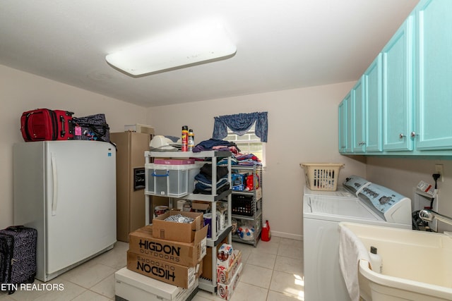 washroom with cabinets, light tile patterned flooring, washer and clothes dryer, and sink