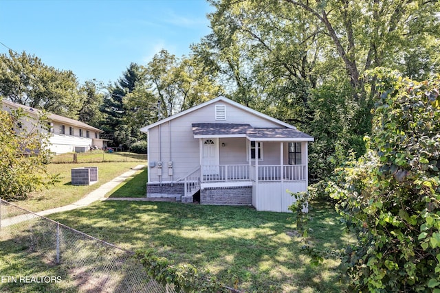 view of front of property featuring cooling unit, a front yard, and covered porch