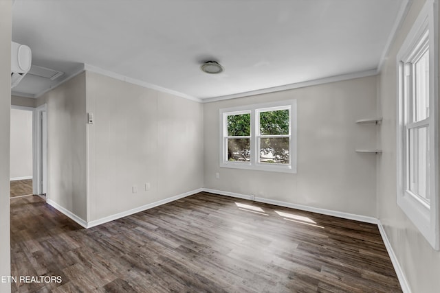 spare room with crown molding, baseboards, and wood finished floors