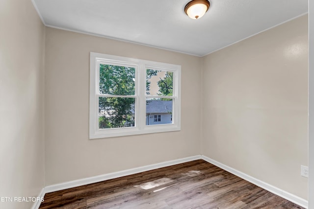 empty room featuring wood finished floors and baseboards