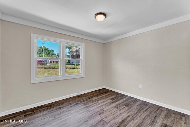 empty room featuring dark wood-type flooring and baseboards