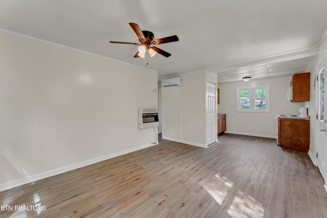 unfurnished living room featuring a wall unit AC, heating unit, ceiling fan, light wood-type flooring, and baseboards