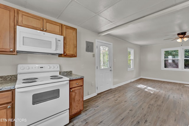 kitchen featuring light wood finished floors, white appliances, brown cabinetry, and baseboards