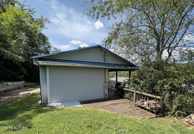 rear view of house featuring a wooden deck and a lawn