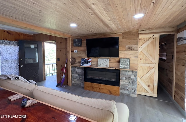 living room with wood ceiling, wooden walls, a stone fireplace, and wood-type flooring