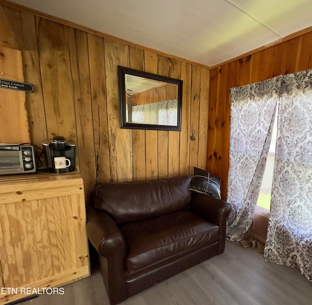 living area featuring hardwood / wood-style floors and wooden walls