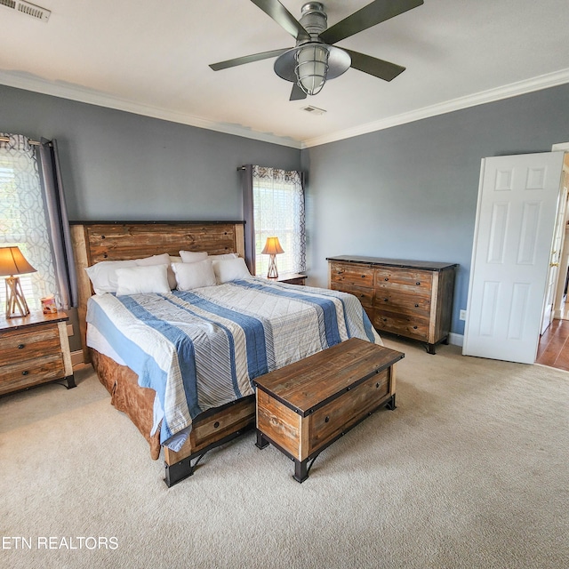 carpeted bedroom with ceiling fan and crown molding