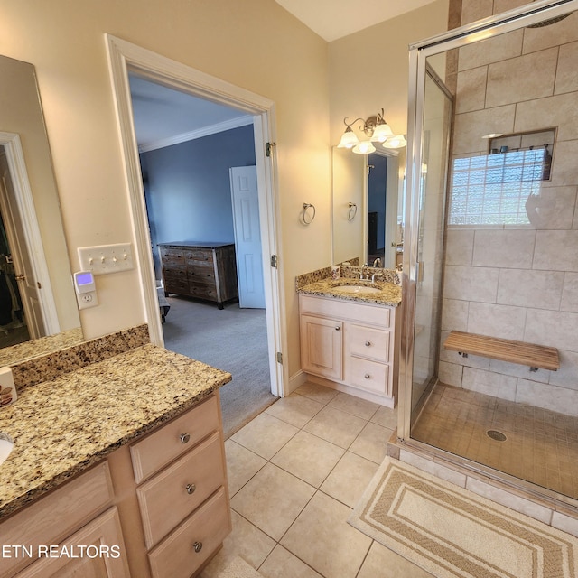 bathroom featuring tile patterned flooring, an enclosed shower, and vanity