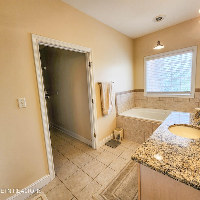 bathroom featuring a relaxing tiled tub, vanity, and tile patterned floors