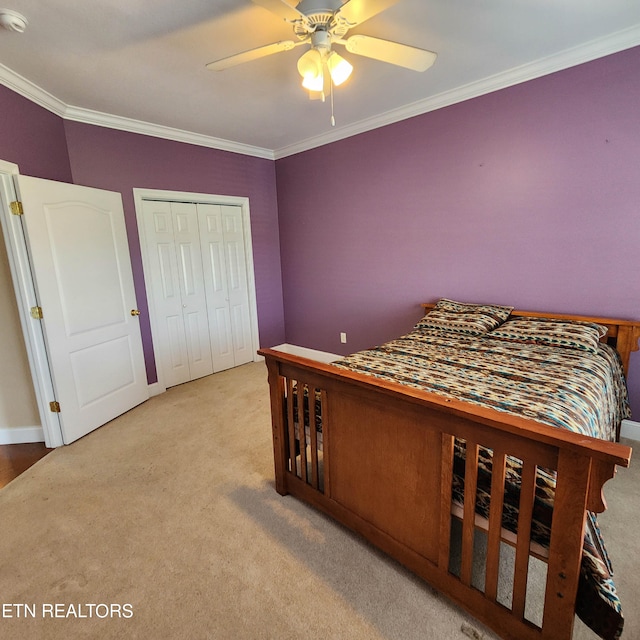 bedroom featuring a closet, ceiling fan, ornamental molding, and light colored carpet