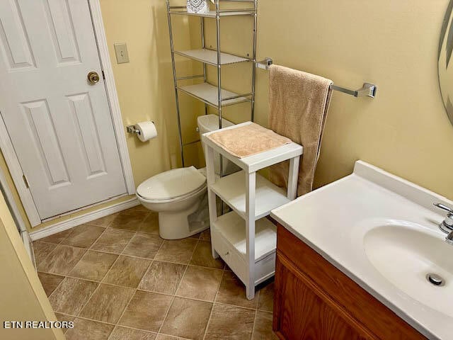 bathroom featuring tile patterned flooring, toilet, and vanity