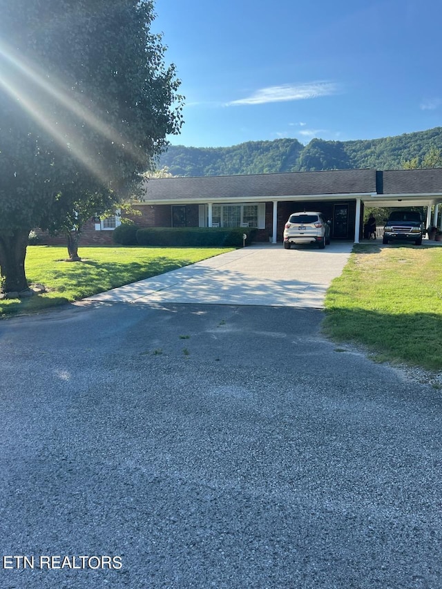 single story home with a mountain view, a carport, and a front yard