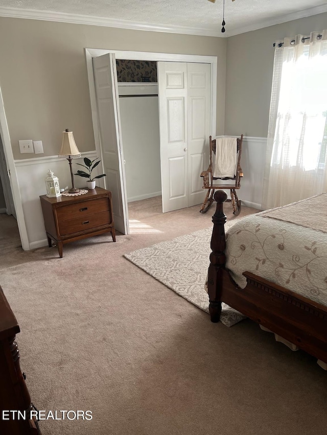 bedroom featuring ornamental molding, a textured ceiling, a closet, and carpet flooring