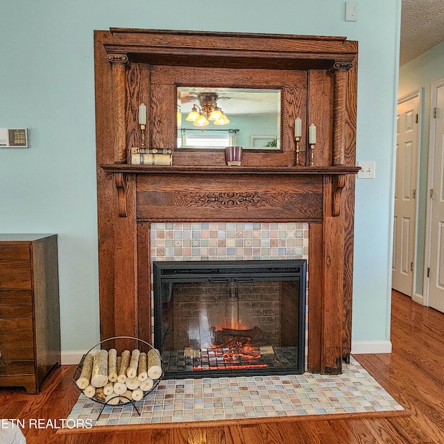 room details featuring a fireplace, wood finished floors, and baseboards