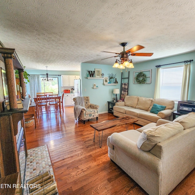 living room with a ceiling fan, baseboards, and hardwood / wood-style flooring