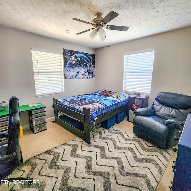 bedroom with carpet, baseboards, ceiling fan, and a textured ceiling