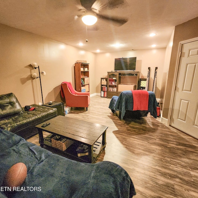 living room with ceiling fan, wood finished floors, and baseboards