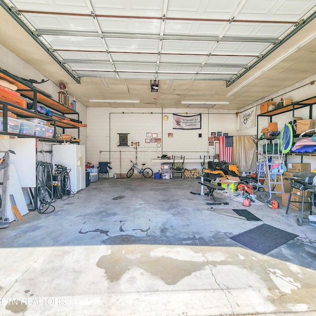 garage with white fridge with ice dispenser and a garage door opener