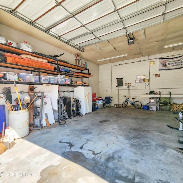 garage with white fridge with ice dispenser and a garage door opener