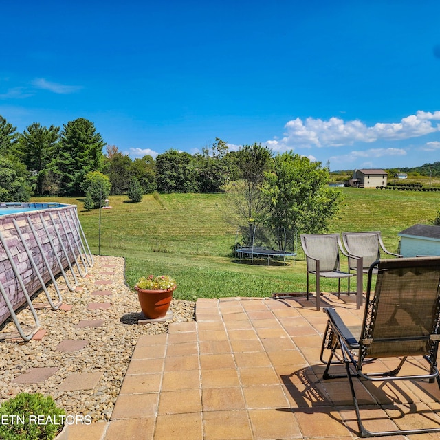 view of patio / terrace featuring a trampoline and an outdoor pool